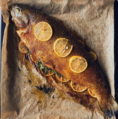 Grilled fish with lemon wedges on it