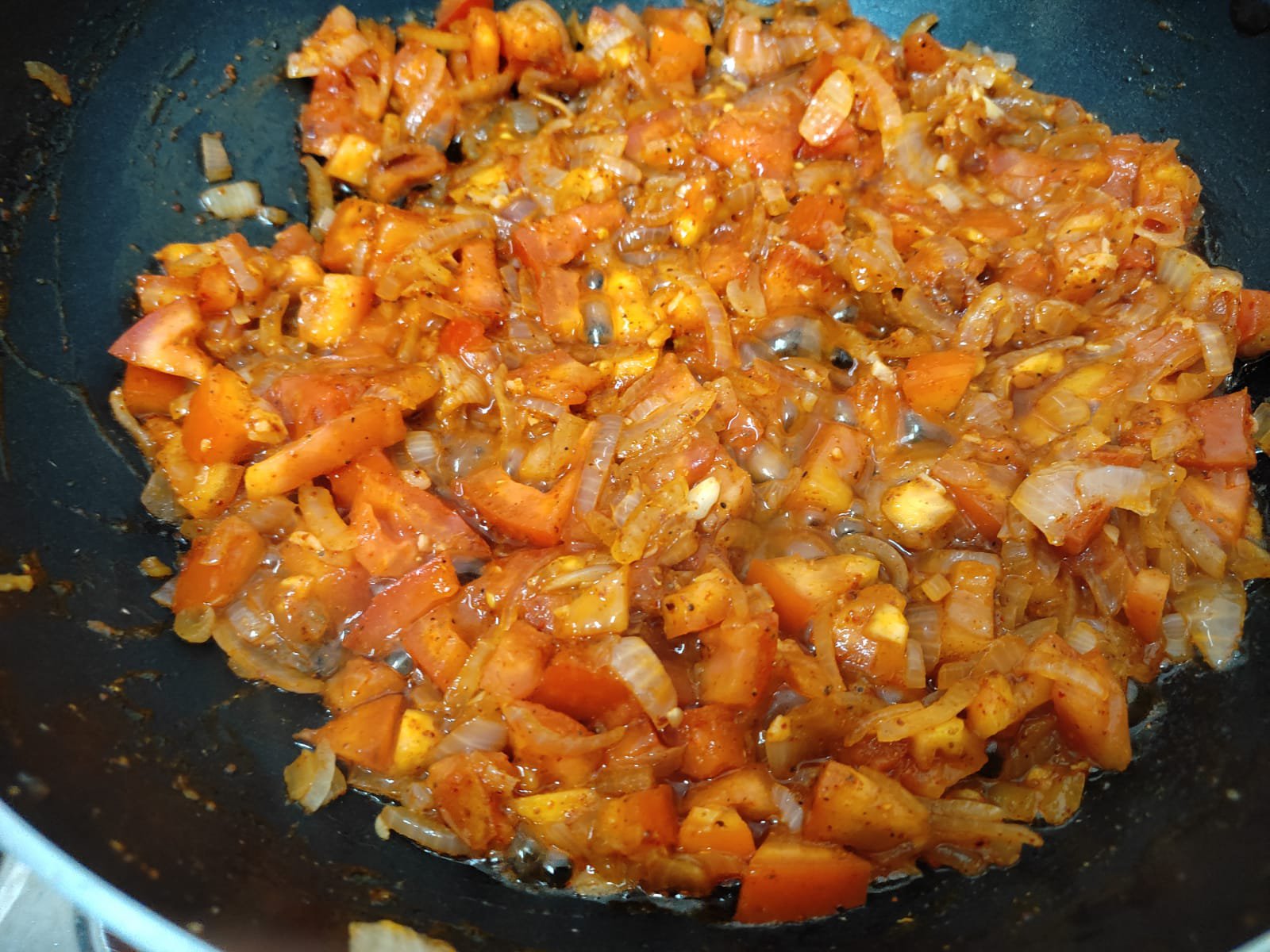 Onions and tomatoes frying in oil