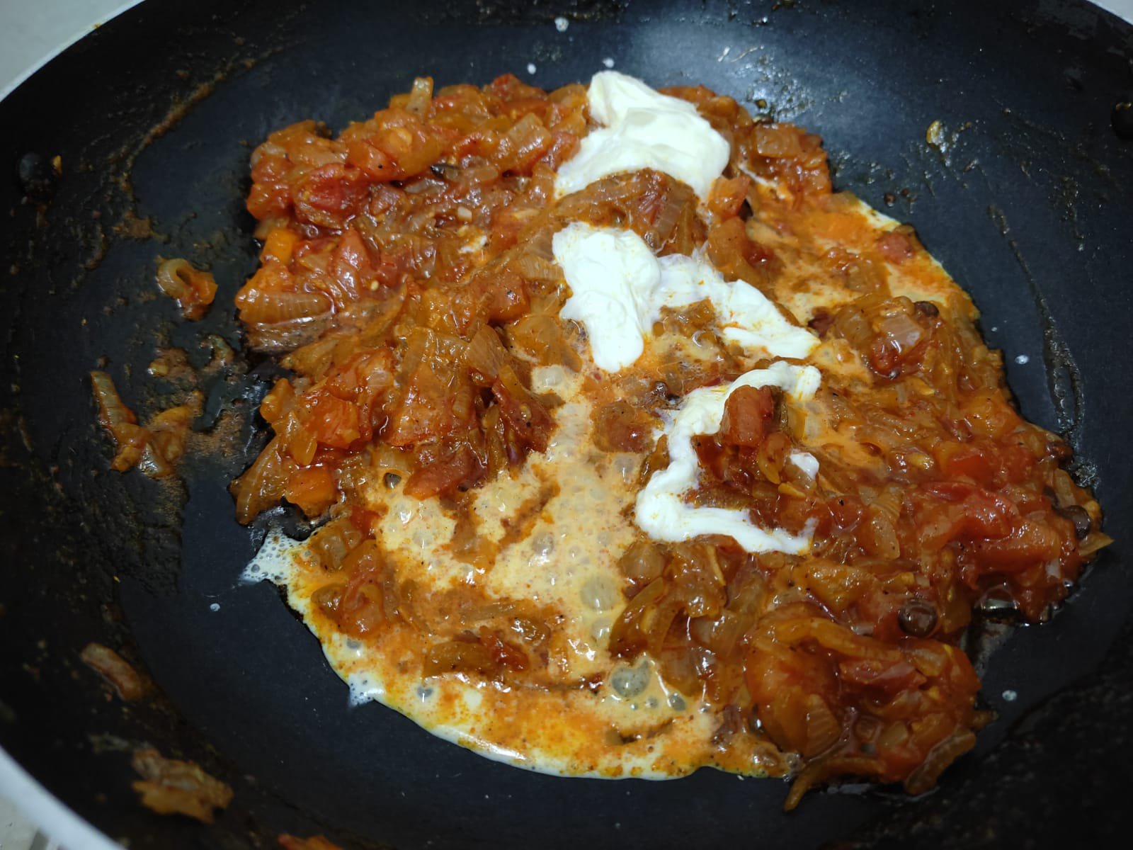 Adding cream in sauteed onions and tomatoes