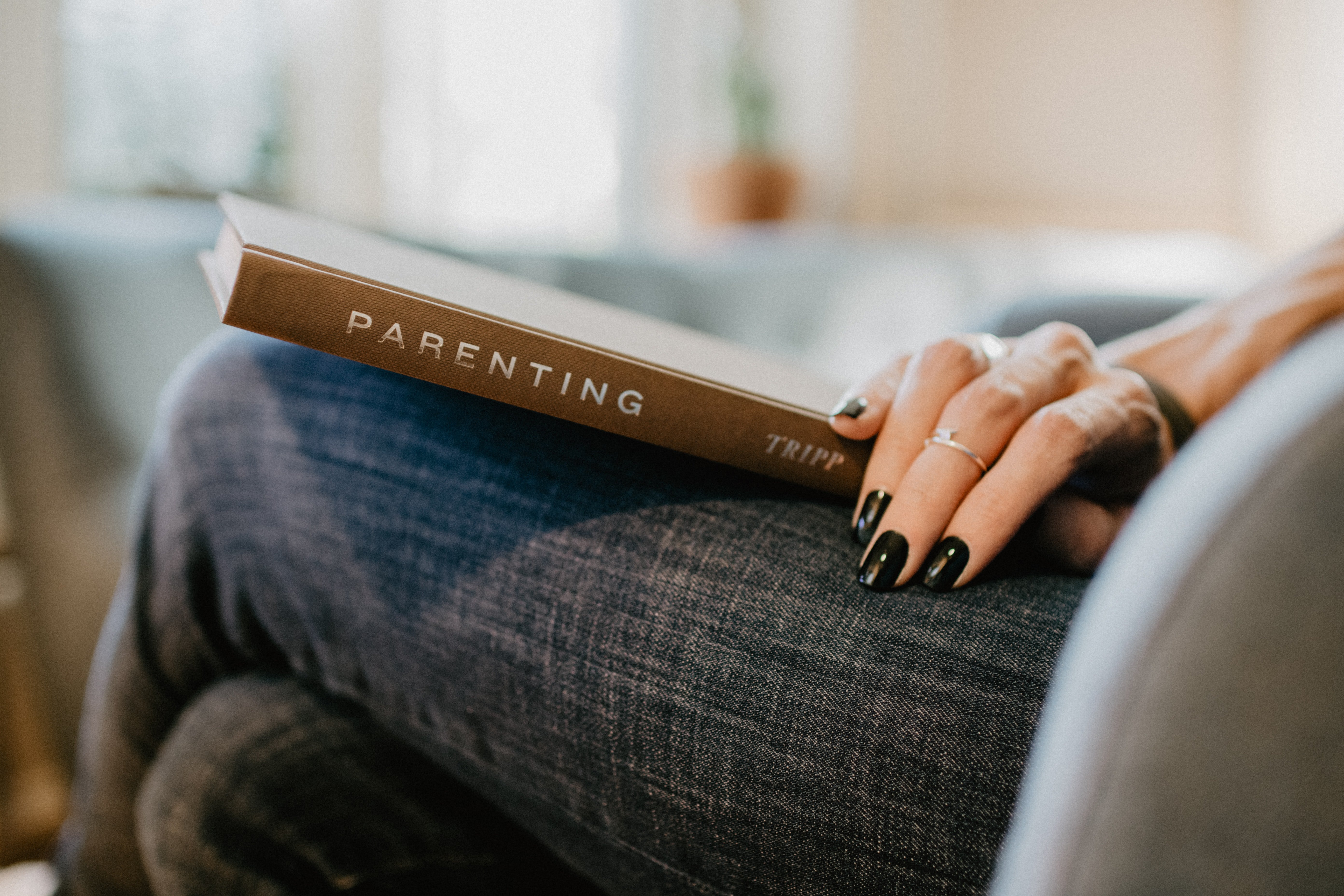 a book on a woman's lap with her hand on it
