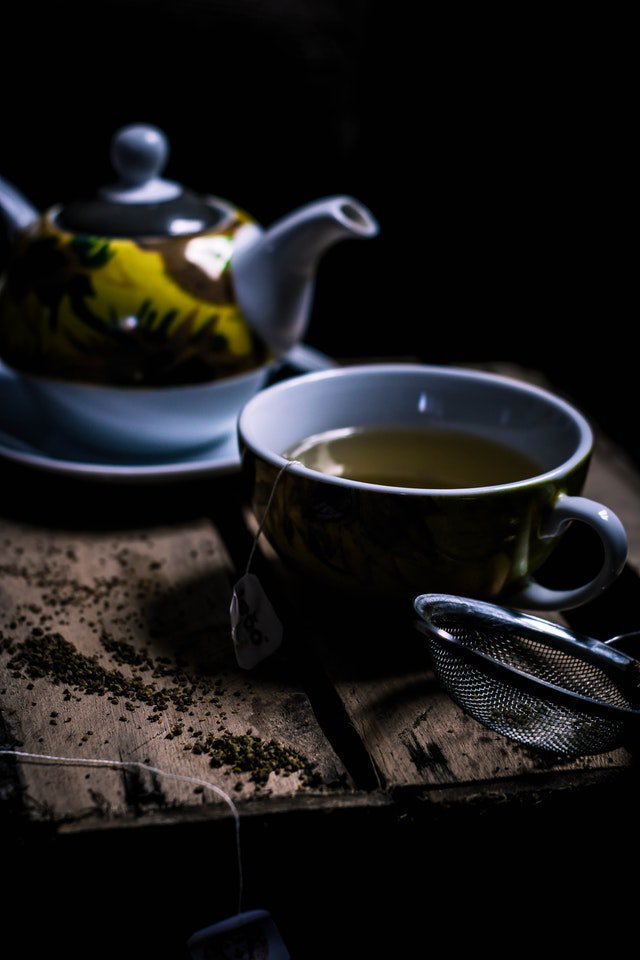 a kettle and a cup with green tea